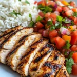 Delicious grilled chicken with colorful fajita vegetables, cilantro rice, and tomato salsa
