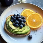 Sunny avocado toast topped with blueberries and served with orange juice